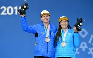 An image of Melissa Perrine and Christian Geiger wearing their medals and smiling