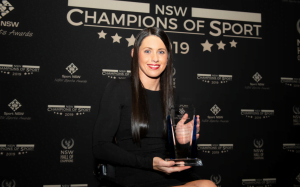An image of a parathlete holding a trophy at the NSW Champions of Sport awards ceremony