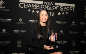 An image of a parathlete holding a trophy at the NSW Champions of Sport awards ceremony