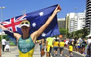 An image of Kate Doughty smiling and holding up the Australian flag