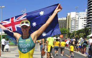 An image of Kate Doughty smiling and holding up the Australian flag