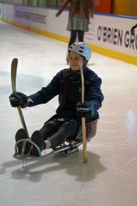 Image of a female athlete playing para-ice hockey