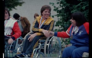female paralympian smiling shaking hands with competitor
