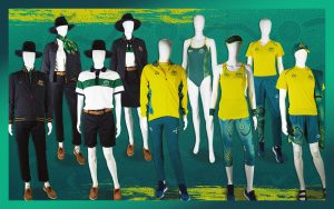Image featuring a green background and 9 mannequins dressed in a variety of uniforms to be worn by the Australian Paralympic Team at the Tokyo 2020 Paralympic Games.