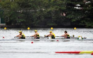 Image of 4 rowers in a boat on the water