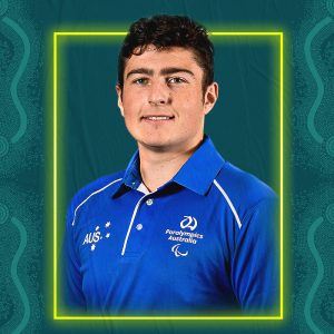 Image containing a dark green background with a yellow border. In the middle is a headshot of Australian para-athlete Corey Anderson looking straight at the camera. He is wearing a blue t-shirt.