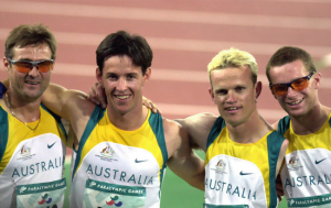 4 male Paralympian athletes: Fuller, Wilson, Matthews, Francis smiling after winning their 4x400m relay race