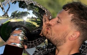 Australian wheelchair tennis player Dylan Alcott holding a trophy and kissing it