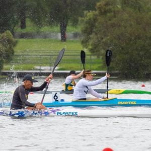 Three athletes canoeing on the water