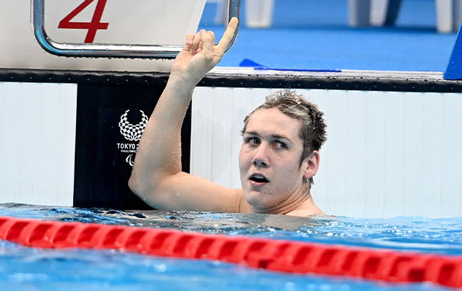Para-swimmer Will Martin celebrating with a finger in the air after a race.