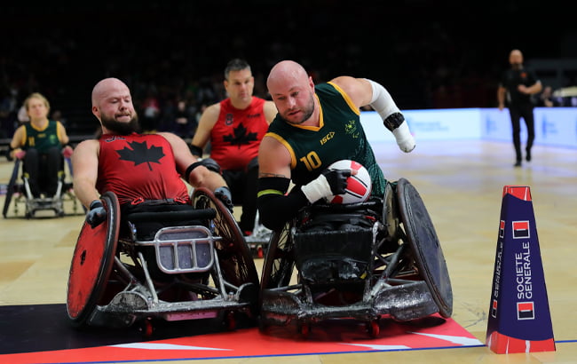 Australian wheelchair rugby captain Chris Bond receives close attention from a Canadian opponent as he tries to score