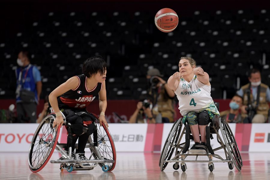 Sarah Vinci throwing basketball on court with her Japanese opponent.